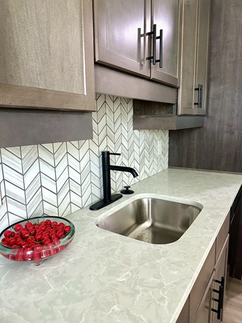 a kitchen with a sink and a bowl of red peppers